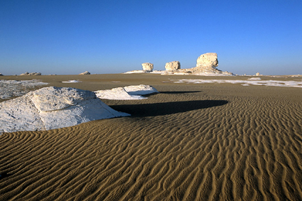 Le sable, provenant de la grande mer de sable de lEst, forme des <i>ripple sands</i>, dus  laction olienne, qui recouvrent progressivement la craie constitutive du socle du dsert Blanc.