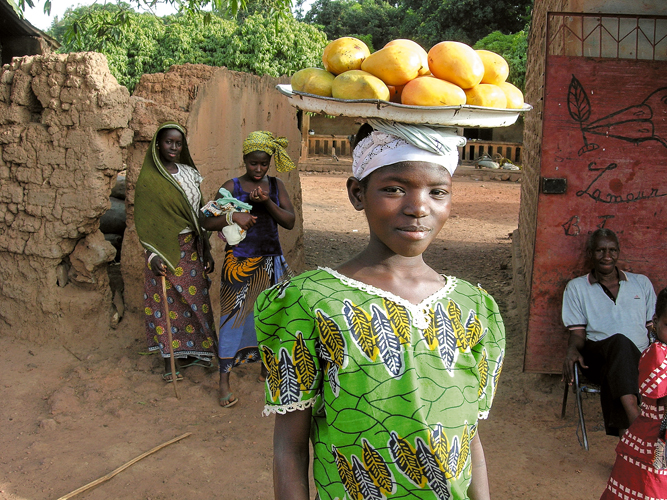 Ds son plus jeune ge, lAfricaine shabitue  porter des charges sur sa tte  Mali.