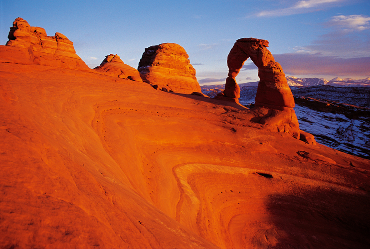 Delicate Arch, compose de grs rouges issus de boue marine, se dresse sur la crte dun cirque de dunes fossilises, dans lUtah (tats-Unis).