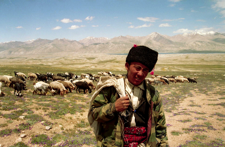 Parcourant le Grand Pamir  <i>pamir</i> signifie alpage ou pturage , ce berger solitaire de SarMokol a en charge une centaine de moutons de ce campement de cinq maisons de pis et quinze yourtes. Derrire lui apparat la tache sombre du lac ZokKol,  cheval sur la frontire de lAfghanistan et du Tadjikistan, et source de lAmou-Darya, lantique fleuve Oxus cit par Hrodote. Les rives tadjikes du lac pourtant si proche, tout comme les cimes qui le dominent, restent inaccessibles aux Kirghizes du Pamir, dmunis de tous papiers didentit.