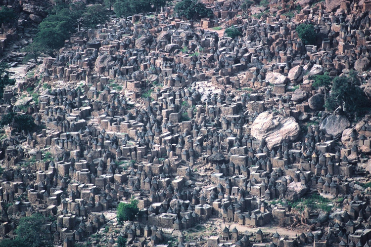 Village de Tiogou. Lhabitat perch dogon se prsente sous une forme groupe, compacte et dense. Cette impression de surpeuplement est une des consquences de lexigut des sites. Localement les densits de population peuvent dpasser 400habitants  lhectare.