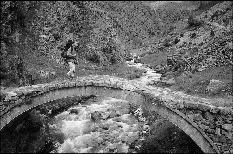 Philippe Valry chemine sur un vieux pont ottoman.