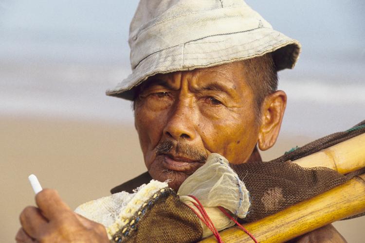 Ce pêcheur âgé de Madura n’embarque plus pour des destinations lointaines. Pour subvenir aux besoins de sa famille, il ramasse les coquillages et les petits poissons qu’il attrape dans son filet le long de la plage.