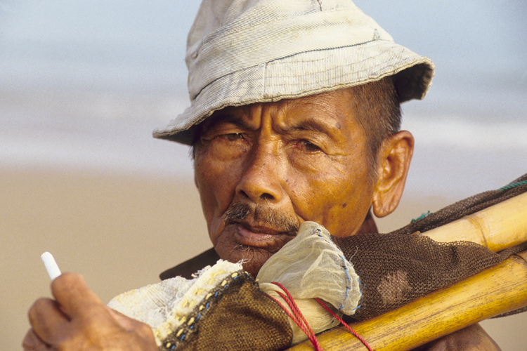 Ce pcheur g de Madura nembarque plus pour des destinations lointaines. Pour subvenir aux besoins de sa famille, il ramasse les coquillages et les petits poissons quil attrape dans son filet le long de la plage.