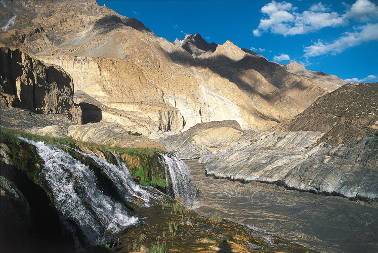 Les sources chaudes de Kuk se jettent dans les eaux boueuses de la Shimshal sous le glacier de Malanguti. La hauteur du Ghujerab Muztagh est écrasante.
